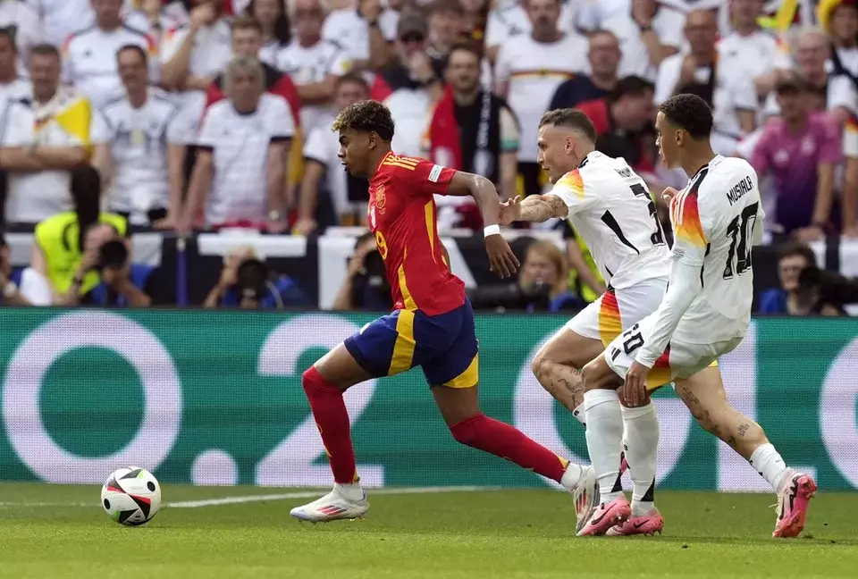 Pemain Jerman  David Raum (tengah) dan Jamal Musiala (kanan) berupaya merebut bola dari kaki pemain Spanyol Lamine Yamal pada pertandingan babak perempat final Euro 2024  di Stuttgart, Jerman, Jumat, 5 Juli 2024.